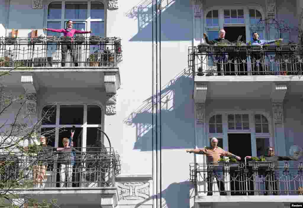 People exercise on their balconies according to the instructions of fitness trainer Patricio Cervantes during the spread of coronavirus disease (COVID-19) in Hamburg, Germany.