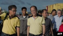 Philippine President Benigno Aquino (R) visits the navy port where some relief supplies arrive by boat in Tacloban, Nov. 17, 2013.