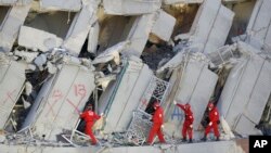 FILE - Emergency rescuers continue to search for missing in a collapsed building from an earthquake in Tainan, Taiwan, Feb. 7, 2016.