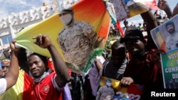 Supporters hold a poster of Mali's transition president, Colonel Assimi Goita, as they participate in a demonstration called by Mali transitional government after ECOWAS (Economic Community of West African States) sanctions in Bamako, Mali, Jan. 14, 2022.