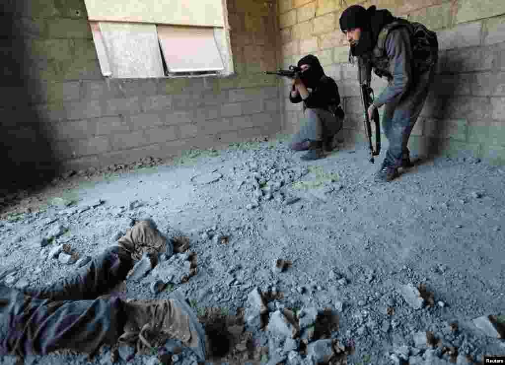 Fighters from the Free Syrian Army's Tahrir al Sham brigade move toward a Syrian Army check point in the Zamalka neighborhood of Damascus, January 25, 2013.