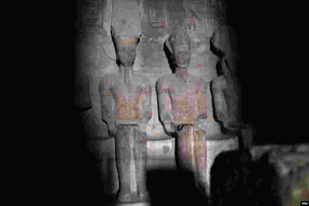Sinar matahari menerpa tempat suci paling dalam untuk menerangi patung Raja Rameses II, istrinya Nefertari, dan dewa Amun Re, hingga Dewa Ptah, dewa dunia kegelapan, diselimuti kegelapan. Fenomena ini terjadi di dua tanggal yang sama, yaitu pada 22 Oktober, tanggal kelahiran Rameses II dan pada 22 Februari, hari penobatan Rameses, setiap tahunnya di kuil Abu Simbel, di Aswan, selatan Mesir, 22 Februari 2018. (H. Elrasam/VOA)