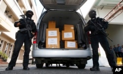 FILE - Thai policemen stand guard next to 100 kilograms of seized marijuana before a news conference Bangkok, Thailand, Tuesday, Sept. 25, 2018.