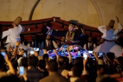 Tarian tradisional Sufi ditampilkan di depan Masjid Umayyah, Damaskus, Suriah, selama bulan suci Ramadan, 8 Juni 2018. (REUTERS / Omar Sanadiki)