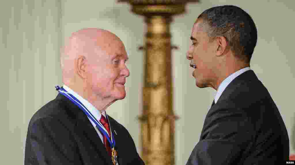 លោក​ប្រធានាធិបតី​ Barack Obama អបអរសាទរ​អតីត​អ្នកបើកបរ​យន្តហោះ​សម្រាប់​ទាហាន​ម៉ារីន​អាមេរិក អវកាសយានិក និង​សមាជិក​ព្រឹទ្ធសភា​លោក John Glenn បន្ទាប់​ពី​ប្រគល់​មេដាយ​សេរីភាព (Medal of Freedom) ឲ្យ​លោក​នៅ​ថ្ងៃ​ទី២៩ ខែ​ឧសភា ឆ្នាំ​២០១២ អំឡុងពេល​ពិធីប្រគល់មេដាយ​នៅ​សេតវិមាន​ក្នុង​រដ្ឋធានី​វ៉ាស៊ីនតោន។&nbsp;