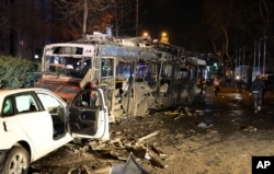 Damaged vehicles are seen at the scene of an explosion in Ankara, Turkey, Sunday, March 13, 2016.