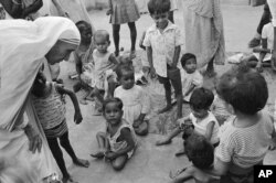 FILE - In this Oct. 25, 1979 file photo, Mother Teresa, left, talks with and blesses the orphans at her Sishu Bhavan (Children's Home) in Kolkata, India.