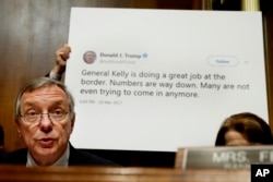 Sen. Dick Durbin, D-Ill., ranking Member of the Senate Committee on the Judiciary, Subcommittee on Border Security and Immigration, speaks while a staffer holds up a Twitter quote by President Donald Trump, during a subcommittee hearing about the border.