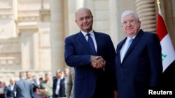 푸아드 마숨 전 이라크 대통령(오른쪽)과 새롭게 선출된 바르함 살리 현 대통령이 3일 이라크 바드다드에서 열린 취임식에서 악수하고 있다. 