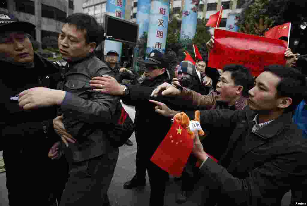 Police separate a supporter of the Southern Weekly from confronting leftists protesting outside the office of the liberal newspaper in the southern Chinese city of Guangzhou, January 9, 2013. 