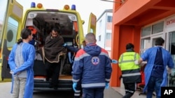 Radnici hitne pomoći u grčkom lučkom gradu Prevezi pomažu preživelom posle nesreće u Egejskom moru. 