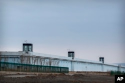 FILE - People stand in a guard tower on the perimeter wall of the Urumqi No. 3 Detention Center in Dabancheng in western China's Xinjiang Uyghur Autonomous Region on April 23, 2021. (AP Photo/Mark Schiefelbein)