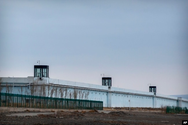 FILE - People stand in a guard tower on the perimeter wall of the Urumqi No. 3 Detention Center in Dabancheng in western China's Xinjiang Uyghur Autonomous Region on April 23, 2021. (AP Photo/Mark Schiefelbein)