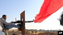 A Libyan rebel fighter aims his heavy machine gun towards forces loyal to Libya's leader Moammar Gadhafi at Misrata's western front line, some 25 kilometers from the city center, May 26, 2011.