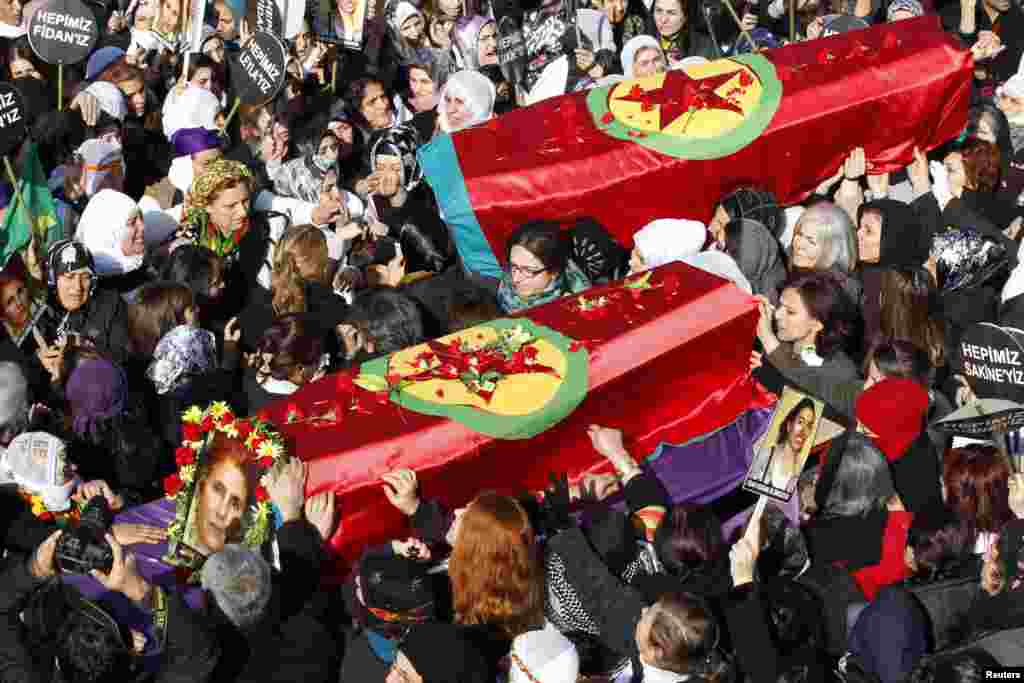 People carry the coffins of the Kurdish activists, who were shot in Paris, during a funeral ceremony in Diyarbakir, the largest city in Turkey&#39;s mainly Kurdish southeast.