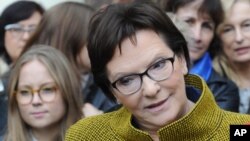 Polish Prime Minister Ewa Kopacz of the Civic Platform party speaks with journalists after meeting with a group of women in Warsaw, Oct. 23, 2015, on the last day of campaigning before Sunday's parliamentary elections.