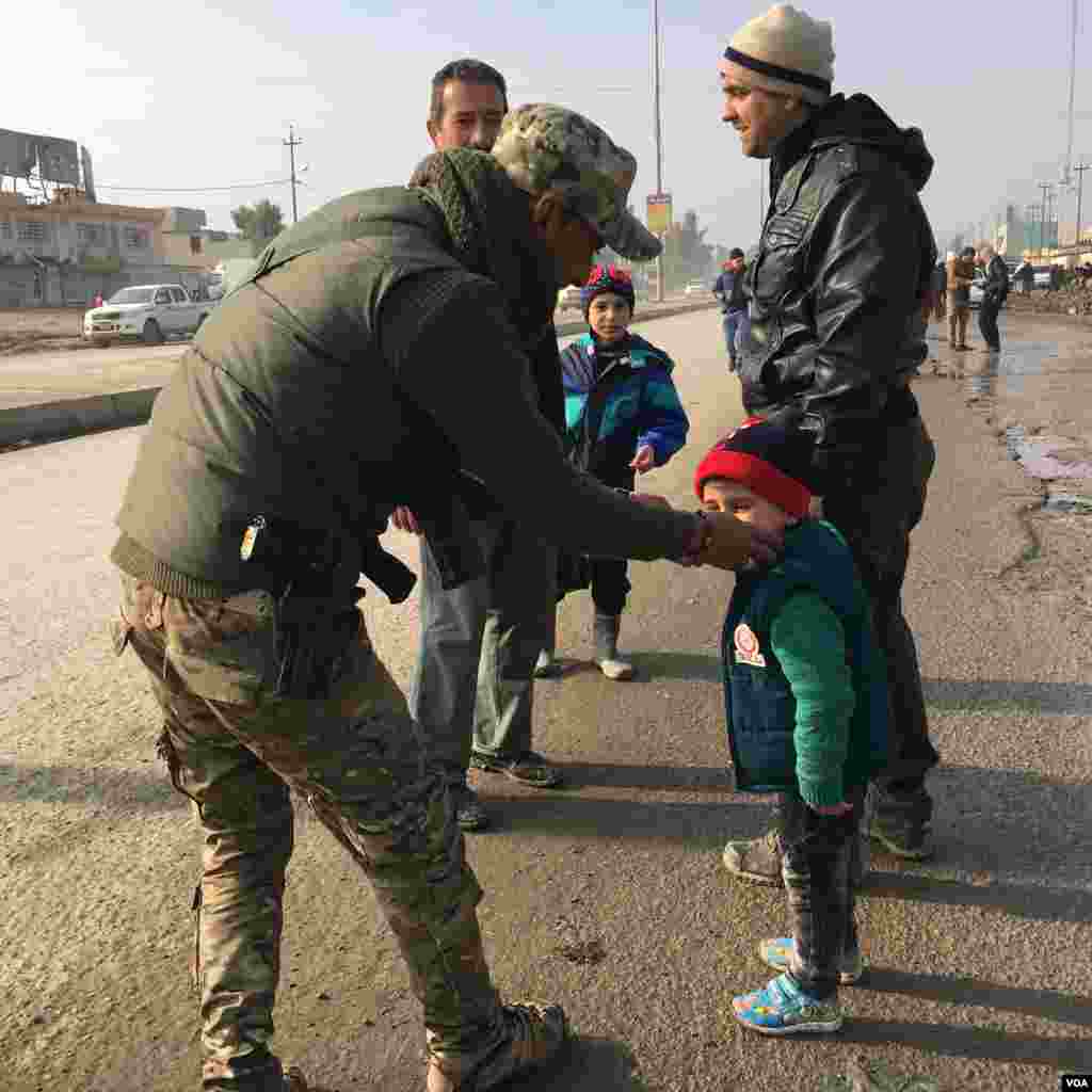 An Iraqi soldier comforts a child. (K. Omar for VOA)