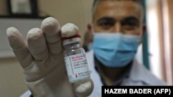 Petugas kesehatan Palestina menunjukkan vaksin COVID-19 produksi Moderna yang dikirimkan oleh Israel di Bethlehem, Tepi Barat (foto: dok). 