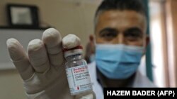 Arhiv - Palestinski zdravstveni radnik drži ampulu Moderna vakcine koju je dostavio Izrael 3. februara 2021. 