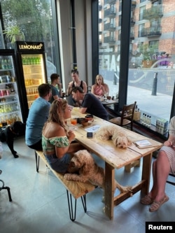 Para pemilik anjing dan hewan kesayangan mereka berbaur di After Bark, bar yang juga membuat koktail untuk hewan, di London, Inggris, 22 Juli 2021. (REUTERS/Tara Oakes)