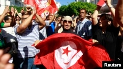 Anti-government protesters wave Tunisian flags as they rally for the dissolution of the Islamist-led government in Sfax, southeast of Tunis, Sep. 26, 2013. 
