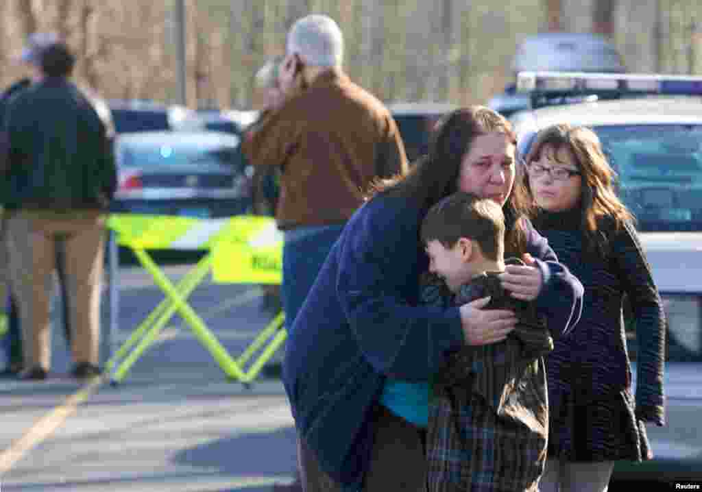 Seorang anak laki-laki ditenangkan di luar Sekolah Dasar Sandy Hook di Newtown, Connecticut, menyusul penembakan yang terjadi. 