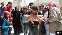 A Syrian man holds the body of his child after it was taken from under the rubble of destroyed buildings following a reported airstrike on the rebel-held neighborhood of al-Marjah in the northern city of Aleppo, July 24, 2016.