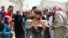 یک مردم سوری جسد کودکش را پس از آنکه از زیر آوار ساختمان های ویران شده در حملات هوایی بیرون کشده شد حمل می کند - ۳ مرداد ۱۳۹۵
