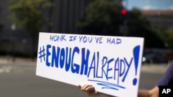 2013年10月2日，一名被停薪休假的美国联邦政府职员在首都华盛顿的大街上高举抗议的标语，要路过的车辆按喇叭以示抗议联邦政府的关闭。