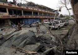 An Afghan policeman inspects the site of a blast near the Indian consulate in Jalalabad, Afghanistan, March 2, 2016.