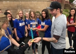 U.S. Olympic freestyle skier David Wise shows off one of his two gold medals to students from Agoura High School, in Agoura Hills, California, Dec. 17, 2018.