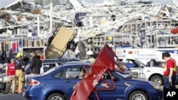 Emergency personnel work around a Lowes Home Improvement store after it was hit by a tornado in Sanford, North Carolina, April 16, 2011