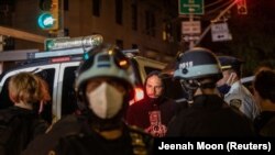 Petugas polisi berdiri di samping para demonstran yang ditahan di dekat taman Washington Square sehari setelah Hari Pemilihan di Manhattan, New York City, New York, AS, 4 November 2020. (Photo: REUTERS/Jeenah Moon)