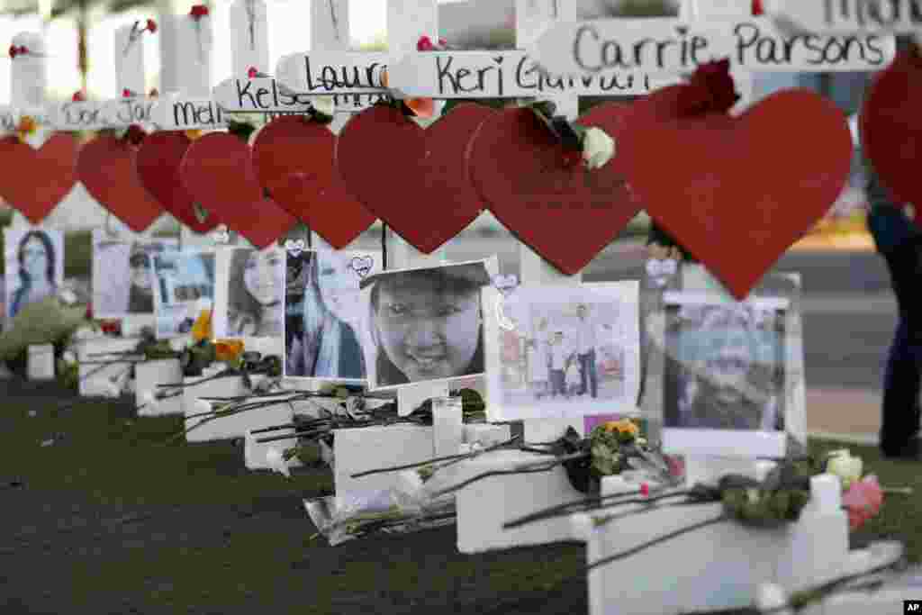美国拉斯维加斯，悼念2017年10月1日枪击惨案死难者的十字架、红色爱心、照片和鲜花，十字架上有每个遇难者的名字。