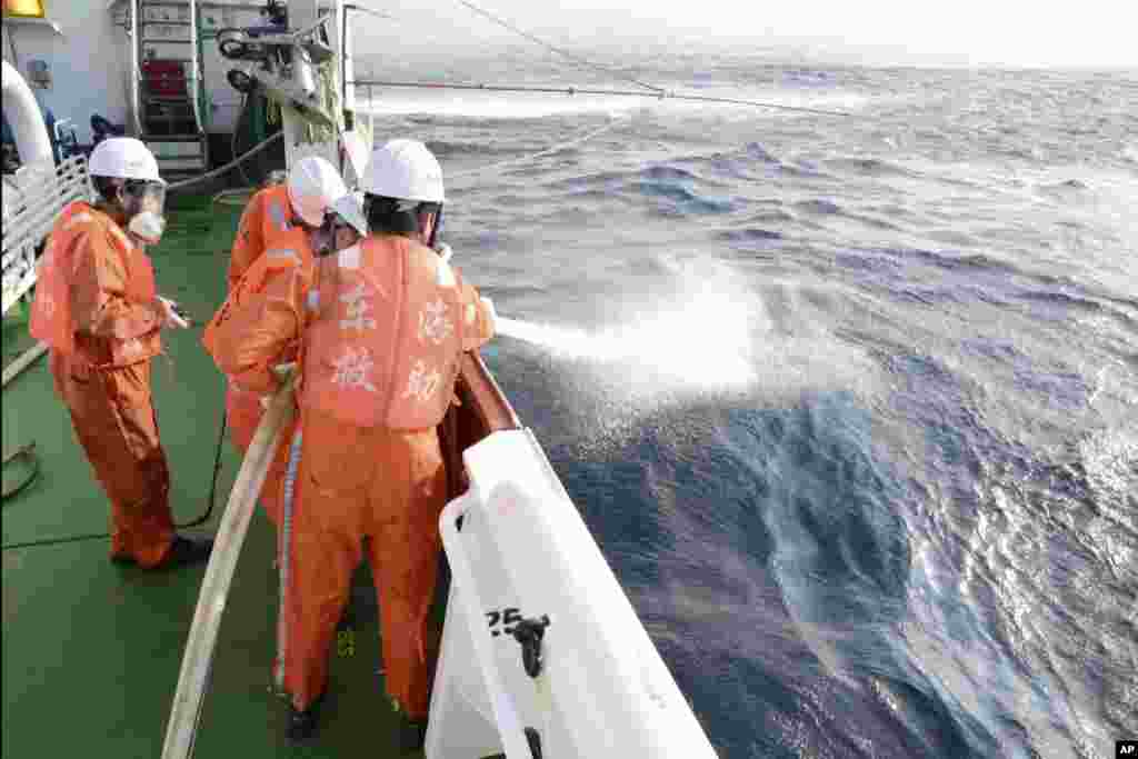 中国海上搜救中心提供的照片显示，伊朗油船沉没后，救援工作人员用水龙向海面浮油喷洒（日期不详）。
