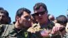 A file photo taken on April 25, 2017 shows a US officer from the US-led coalition, speaking with a fighter from the Kurdish People's Protection Units (YPG) at the site of Turkish airstrikes near northeastern Syrian Kurdish town of Derik.