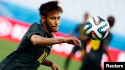 Brazil's Neymar eyes the ball during his team's final practice in Sao Paulo one day before the opening match of the soccer World Cup between Brazil and Croatia, June 11, 2014.