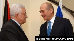FILE - Israeli Prime Minister Ehud Olmert, right, shakes hands with Palestinian President Mahmoud Abbas, in the prime minister's residence in Jerusalem, Oct. 3, 2007. 