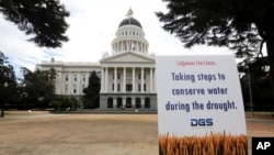FILE - A sign alerts visitors to water conservation efforts at the state Capitol in Sacramento, Calif., July 8, 2014. On Friday, California Gov. Jerry Brown declared an end to the state's water emergency following a five-year drought.