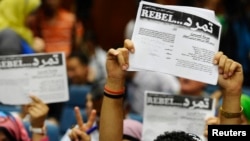 Protesters opposing Egyptian President Mohamed Morsi hold up documents from the "Tamarud" campaign during a news conference at their headquarters in Cairo, May 29, 2013. 
