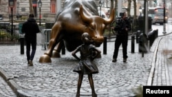 La statue "Fearless Girl" face à la statue du taureau de Wall Street, à New York, le 7 mars 2017