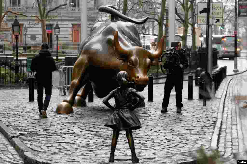 گذاشتن مجسمه &rdquo;دختر نترس&ldquo; رو به روی گاو نر در مقابل ساختمان وال استریت نیویورک&nbsp;در روز جهانی&zwnj; زن.