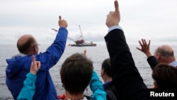 Elected officials and Deepwater Wind executives cheer during a ceremony to mark the installation of the first jacket support structure for a wind farm in the waters of the Atlantic Ocean off Block Island, Rhode Island, July 27, 2015.