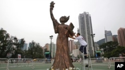 FILE - A worker from the Hong Kong Alliance in Support of Patriotic Democratic Movements in China prepares the Goddess of Democracy statue at Hong Kong's Victoria Park on June 4, 2010. 