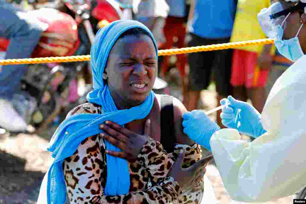 A young woman reacts as she receives the Ebola vaccine, in Goma, Democratic Republic of Congo.