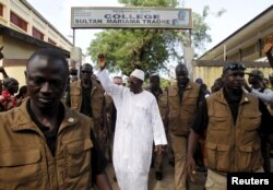FILE - Incumbent President Alpha Conde, leader of Rassemblement du Peuple de Guinea (RPG), wavess as he leaves the polling station during a presidential election in Conakry, Guinea, Oct. 11, 2015.