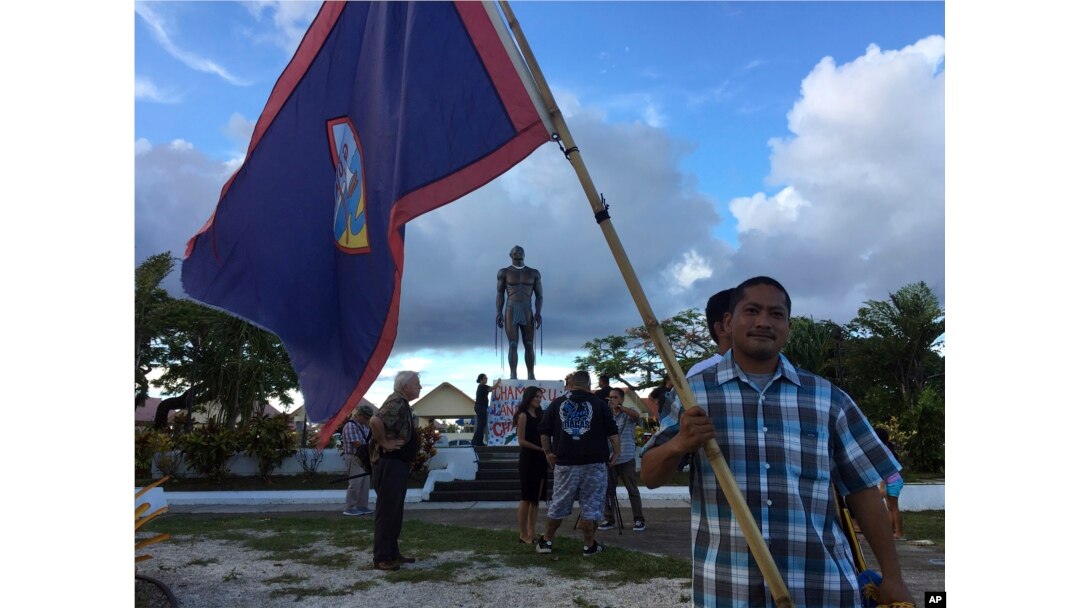 A man holds Guam flag during a peace rally in Hagatna, Guam, Aug, 14, 2017. The threatened missile attack by North Korea on Guam has prompted calls for peace from the island's indigenous people.
