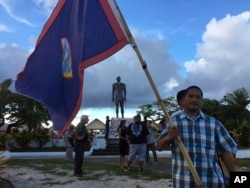 A man holds Guam flag during a peace rally in Hagatna, Guam, Aug, 14, 2017. The threatened missile attack by North Korea on Guam has prompted calls for peace from the island's indigenous people.