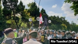 Kelompok orang menolak diskusi buku Ahmadiyah di Bandung, Januari 2019, dengan pengawalan ketat kepolisian. (Foto: VOA/Rio Tuasikal)