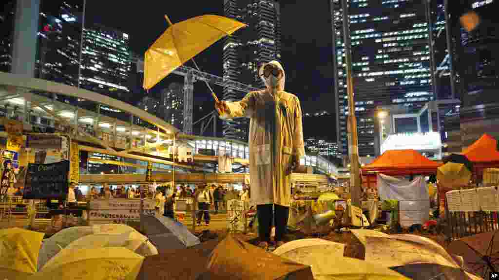 A protester holds an umbrella during a performance on a main road in the occupied areas outside government headquarters in Hong Kong's Admiralty in Hong Kong, Oct. 9, 2014. 